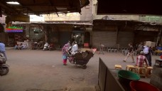 印度妇女在德里大街停放着一辆手推车。