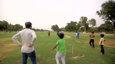 在公园里玩板球的印度孩子